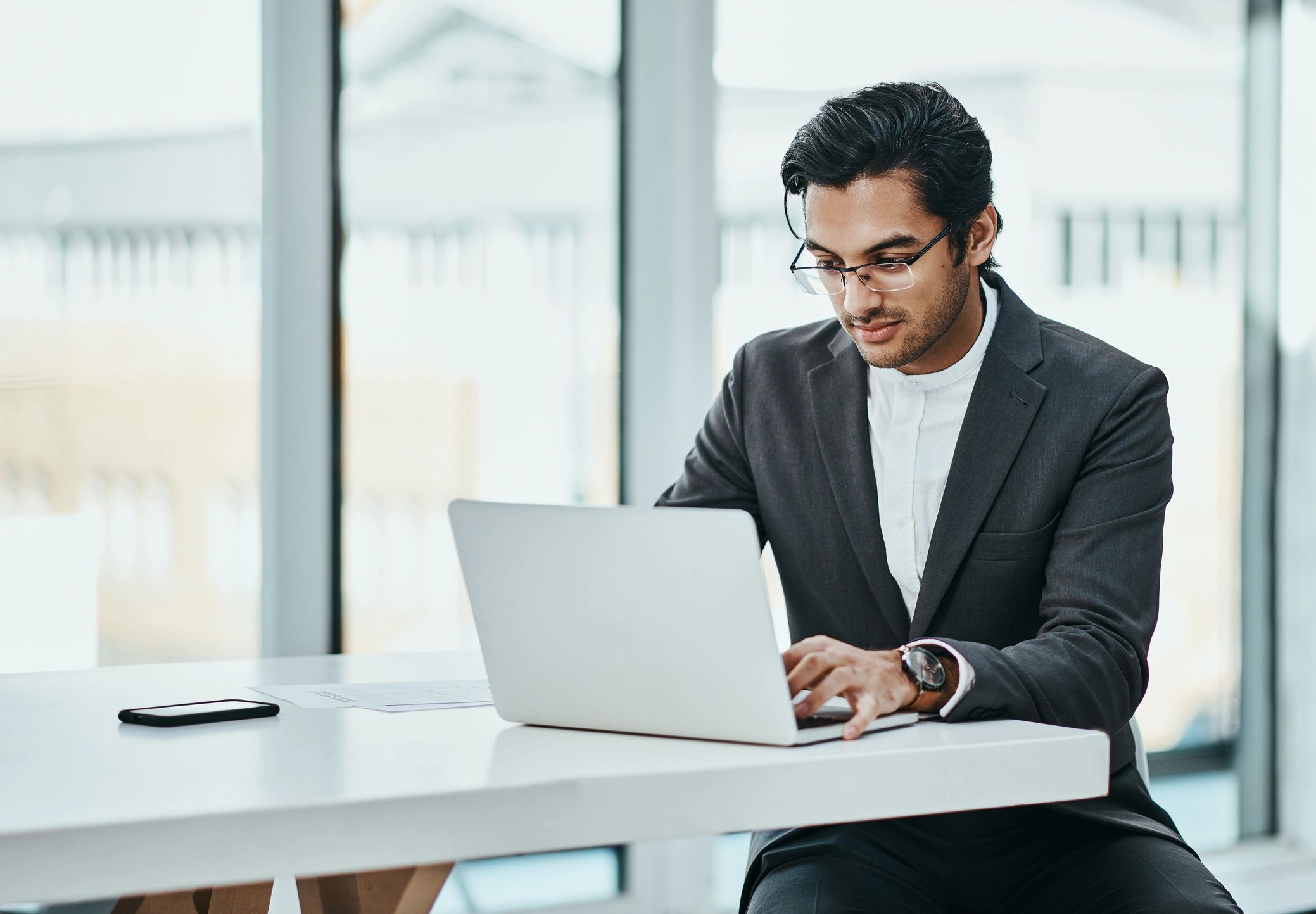 Young professional working on a laptop in a modern office
