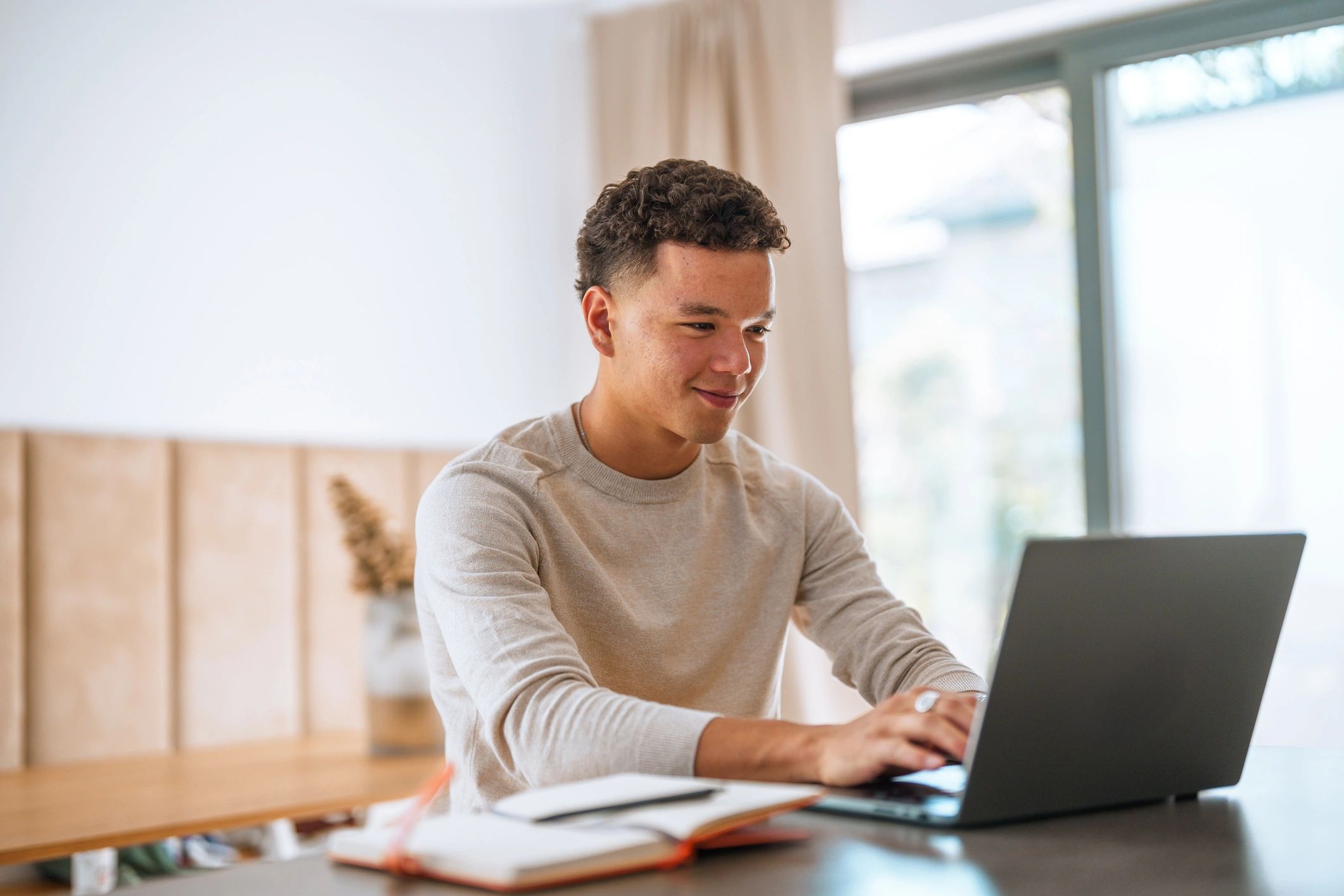 Young professional working on a laptop reviewing finances